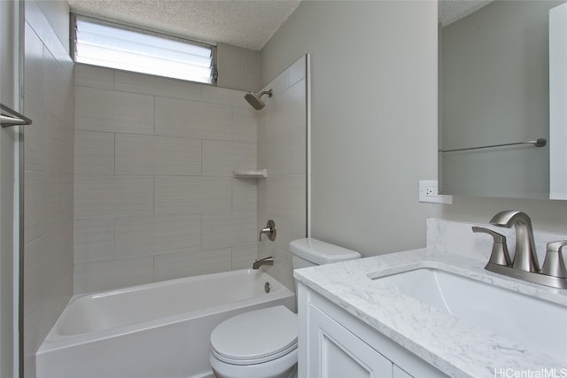 full bathroom featuring tiled shower / bath, vanity, a textured ceiling, and toilet