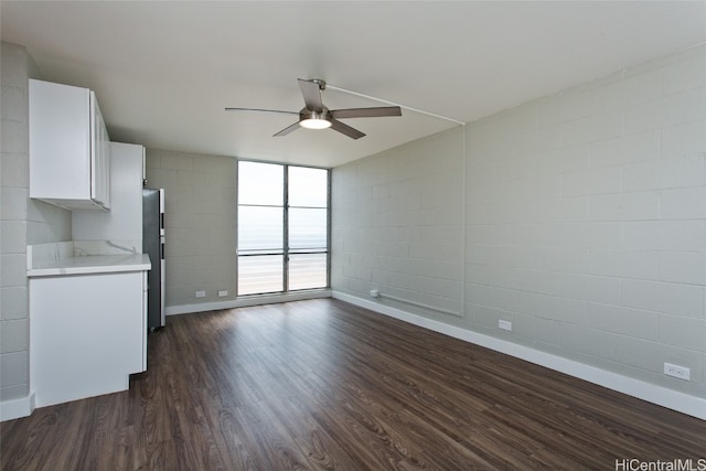 interior space with stainless steel fridge, dark wood-type flooring, white cabinets, and ceiling fan