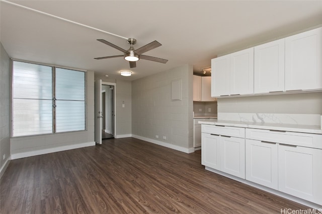 kitchen with dark wood-type flooring, ceiling fan, and white cabinets