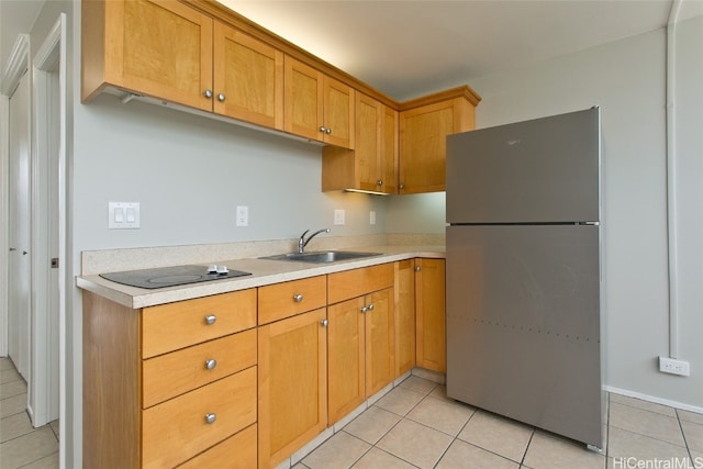 kitchen with light tile patterned flooring, electric cooktop, stainless steel fridge, and sink