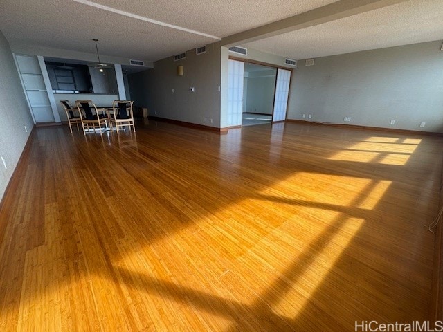 unfurnished room with a textured ceiling and hardwood / wood-style floors