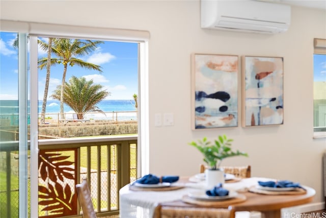 dining room featuring a water view, a wealth of natural light, and a wall mounted air conditioner