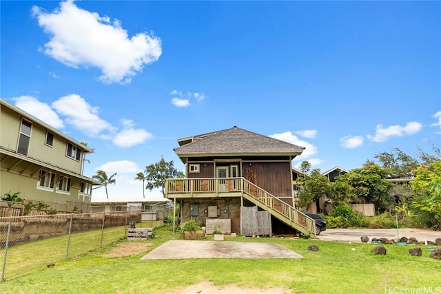 back of house featuring a patio area, a wooden deck, and a lawn