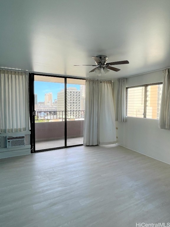 unfurnished room with ceiling fan, cooling unit, and a wealth of natural light