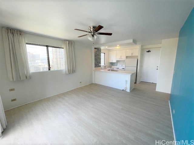 unfurnished living room with ceiling fan and light hardwood / wood-style floors