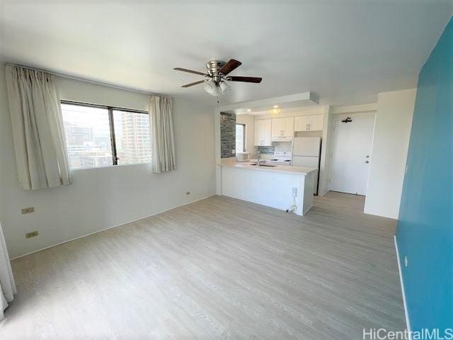 unfurnished living room with light wood-style floors and ceiling fan