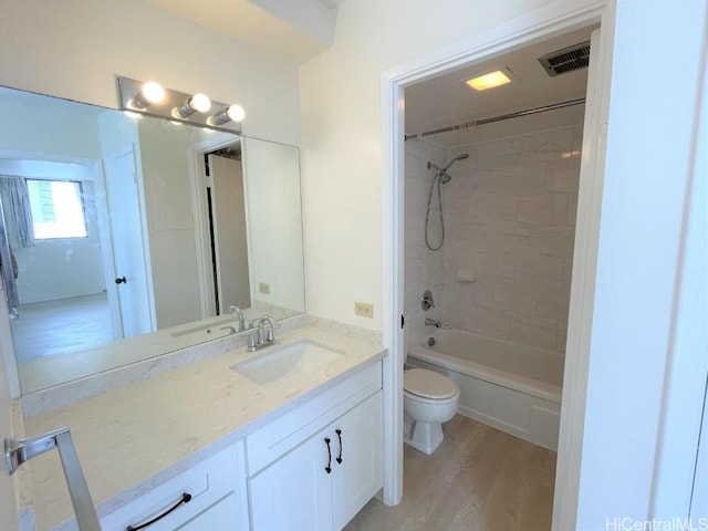 bathroom featuring bathing tub / shower combination, visible vents, toilet, vanity, and wood finished floors