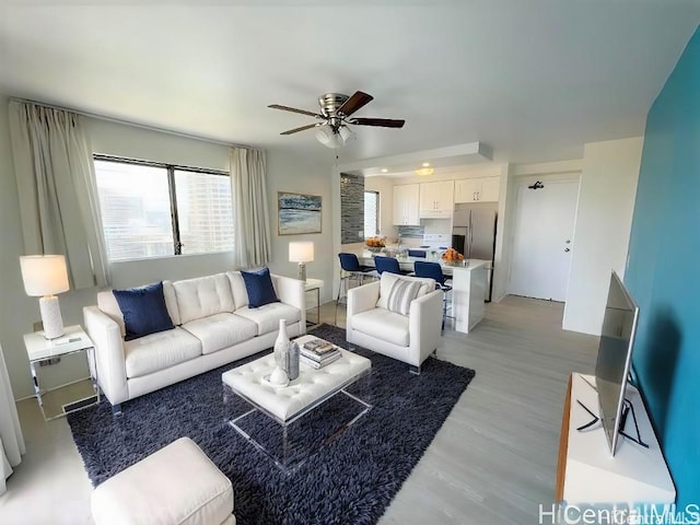 living room with ceiling fan and light wood finished floors