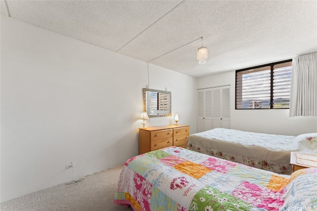 carpeted bedroom with a textured ceiling and a closet