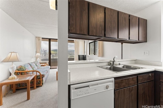 kitchen featuring white dishwasher, light colored carpet, a textured ceiling, and sink