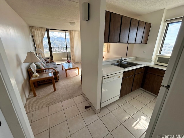 kitchen with sink, white appliances, dark brown cabinets, and light colored carpet