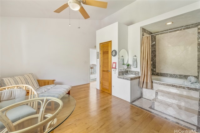 sitting room with light hardwood / wood-style flooring, ceiling fan, and vaulted ceiling