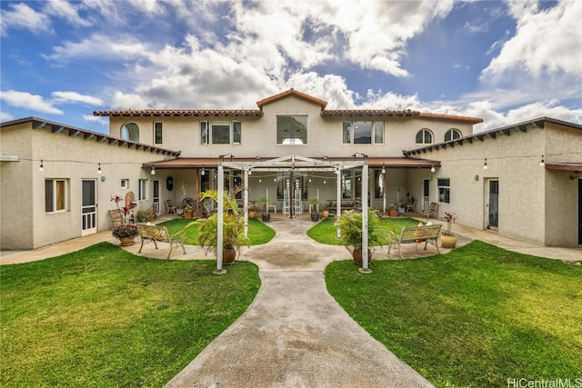 rear view of property featuring a patio, a yard, and a pergola