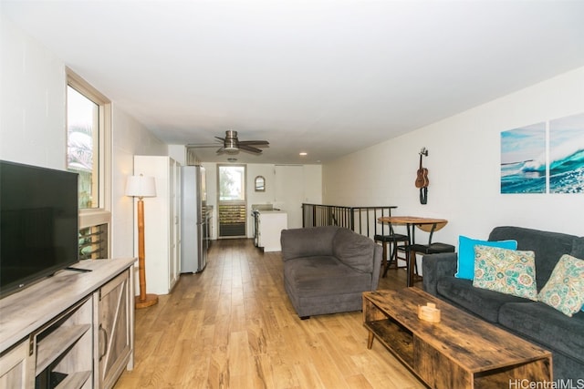 living room with light hardwood / wood-style floors and ceiling fan