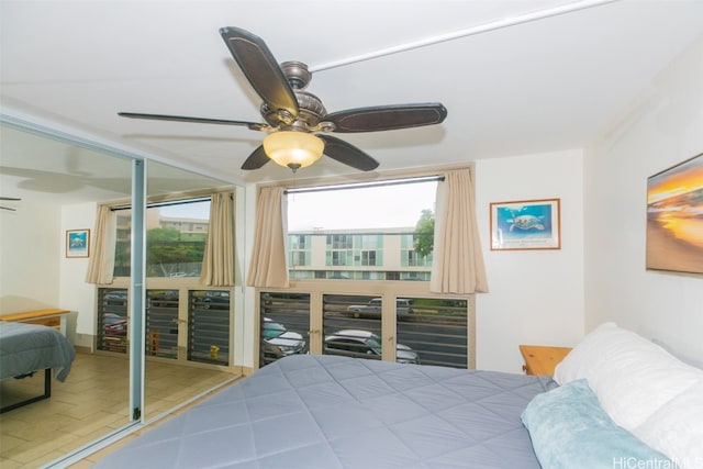 bedroom with multiple windows, a closet, beverage cooler, and ceiling fan