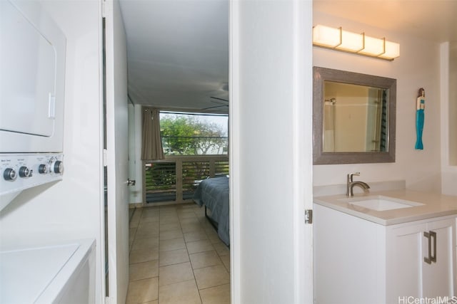 bathroom featuring vanity, stacked washer and clothes dryer, and tile patterned floors