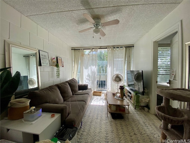 living room with ceiling fan and a textured ceiling