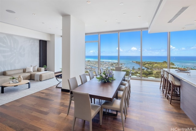 dining area featuring a wall of windows, a water view, and dark hardwood / wood-style flooring