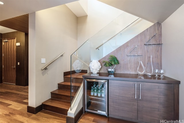 bar featuring wine cooler and hardwood / wood-style floors