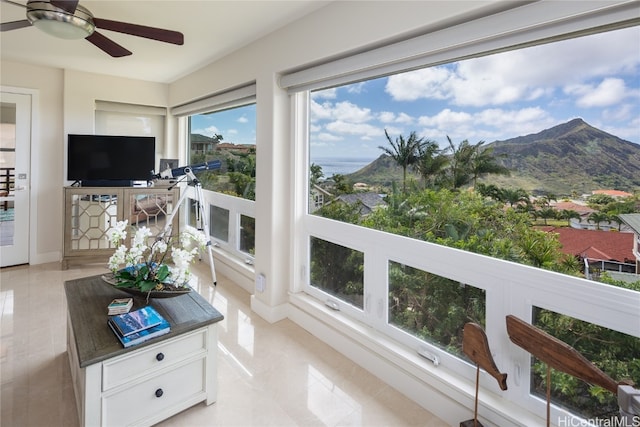 sunroom with a mountain view and ceiling fan