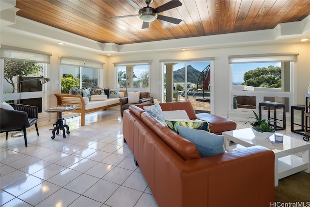 tiled living room with a tray ceiling, a healthy amount of sunlight, and wooden ceiling