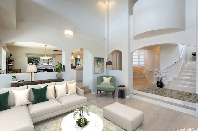 living room with an AC wall unit and a high ceiling