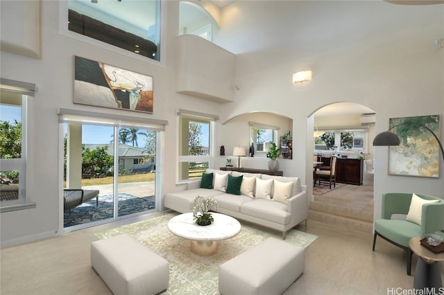 living room featuring an AC wall unit and a towering ceiling