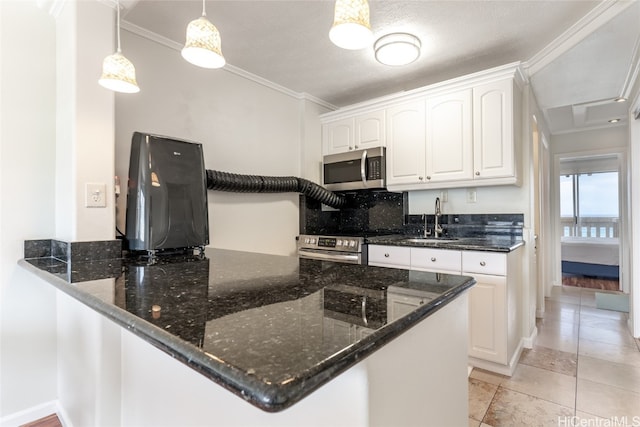 kitchen featuring kitchen peninsula, white cabinets, appliances with stainless steel finishes, sink, and decorative light fixtures