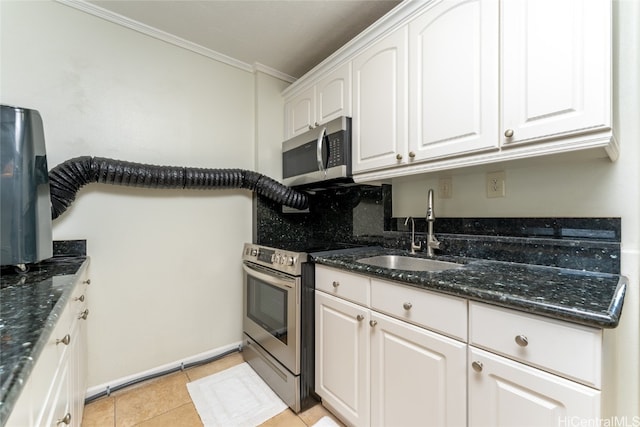 kitchen with stainless steel appliances, dark stone countertops, crown molding, sink, and white cabinetry