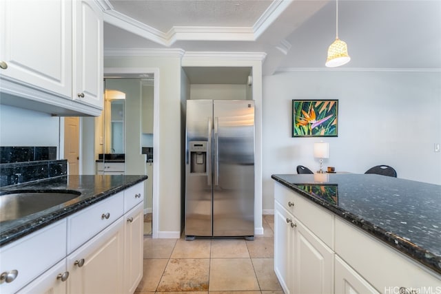 kitchen featuring white cabinetry, pendant lighting, dark stone countertops, crown molding, and stainless steel fridge with ice dispenser