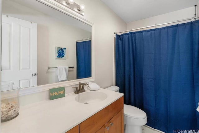 bathroom with toilet, a shower with shower curtain, and vanity