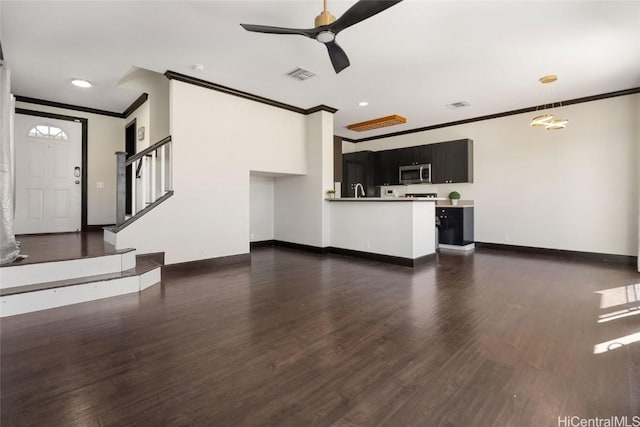 unfurnished living room with ceiling fan, crown molding, and dark wood-type flooring