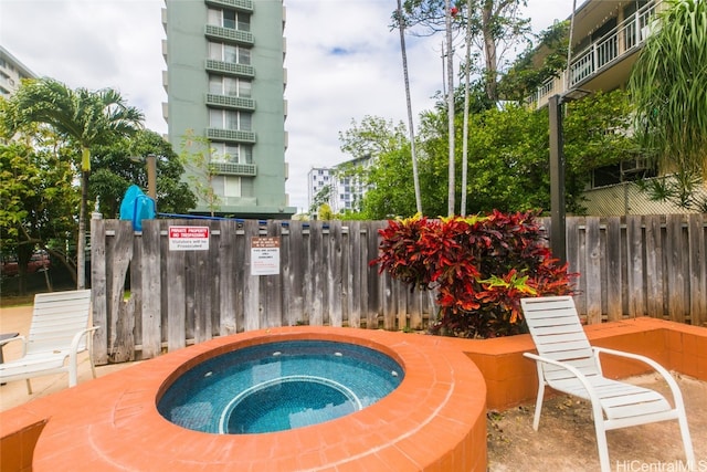 view of swimming pool featuring a hot tub