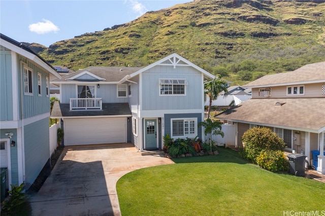 view of front of house featuring a garage, a front lawn, and a mountain view