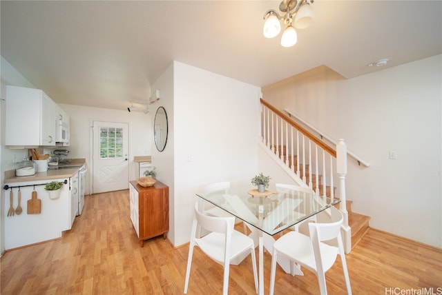 dining space with a notable chandelier and light hardwood / wood-style flooring