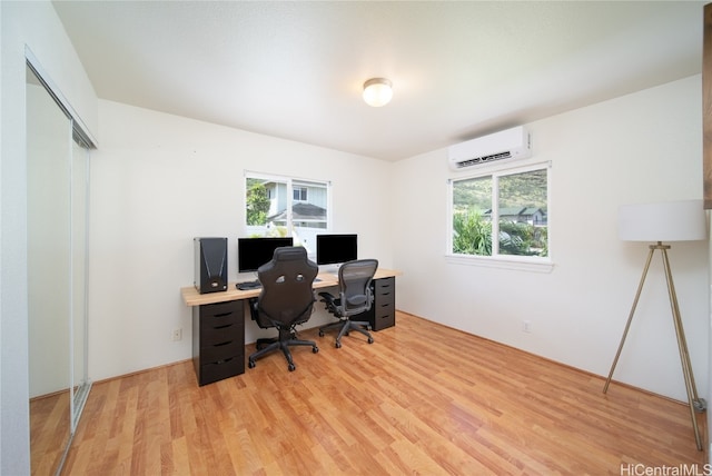 office space with a wall unit AC, light hardwood / wood-style floors, and plenty of natural light