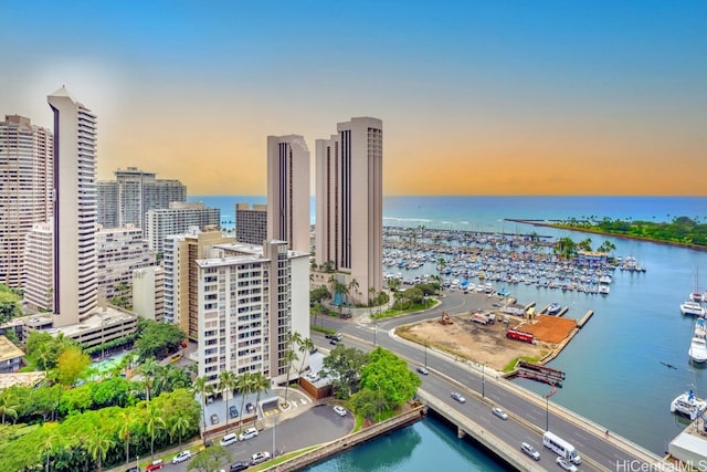 aerial view at dusk featuring a water view