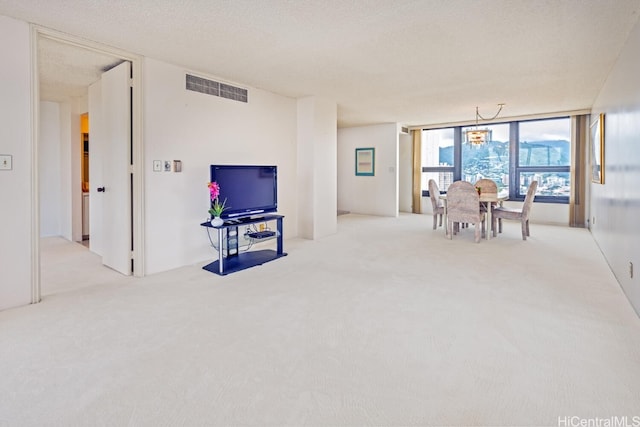 carpeted living room with a textured ceiling and a wall of windows