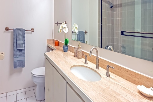 bathroom featuring toilet, vanity, tile patterned flooring, and tiled shower