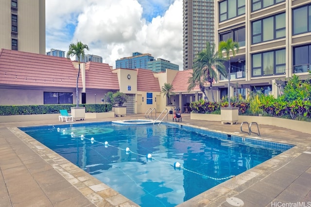 view of swimming pool featuring a patio area and a hot tub