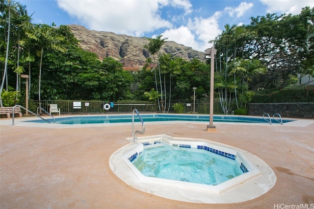 view of swimming pool featuring a mountain view and a hot tub