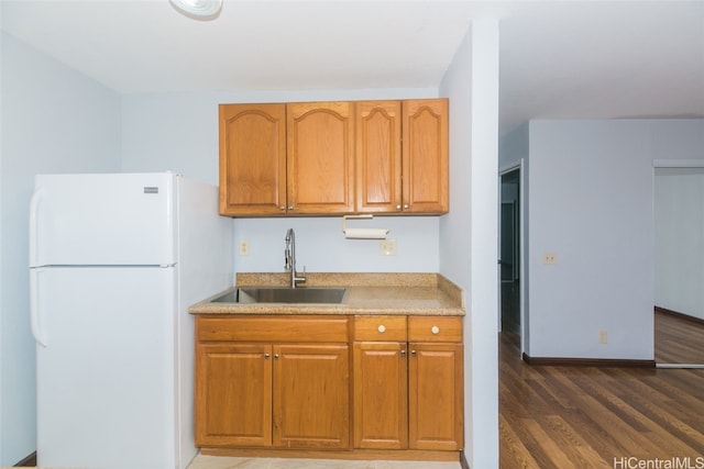 kitchen with dark wood-type flooring, sink, and white refrigerator