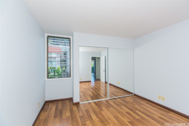 unfurnished bedroom featuring a closet and dark wood-type flooring