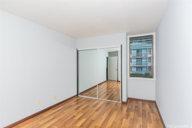 unfurnished bedroom featuring hardwood / wood-style flooring and a closet