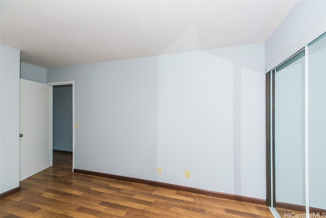 unfurnished bedroom featuring dark wood-type flooring and a closet