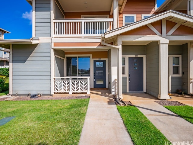 entrance to property with a yard and a balcony