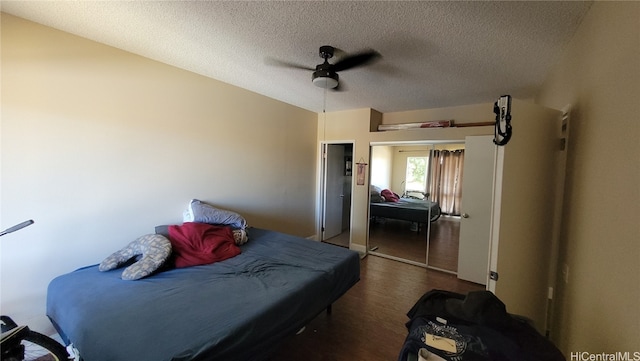 bedroom featuring a textured ceiling, dark hardwood / wood-style floors, a closet, and ceiling fan