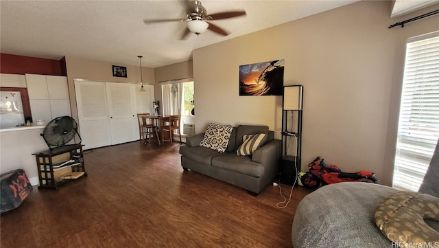 living room featuring a textured ceiling, ceiling fan, and dark hardwood / wood-style flooring