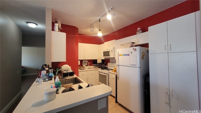 kitchen with sink, white cabinets, a textured ceiling, and white appliances