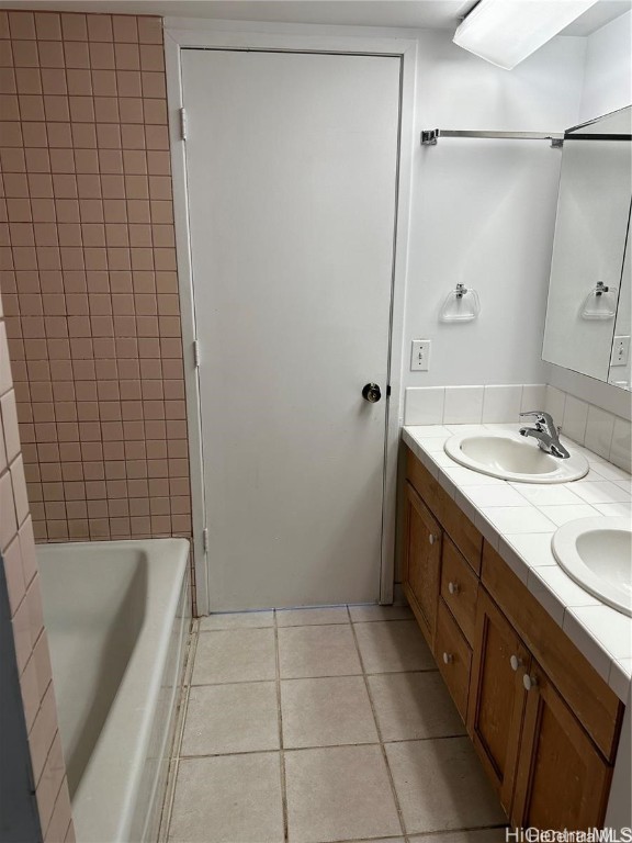 bathroom with vanity, tiled shower / bath, and tile patterned flooring